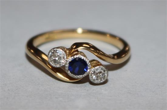 An early 20th century 18ct gold and three stone sapphire and diamond ring, size L.